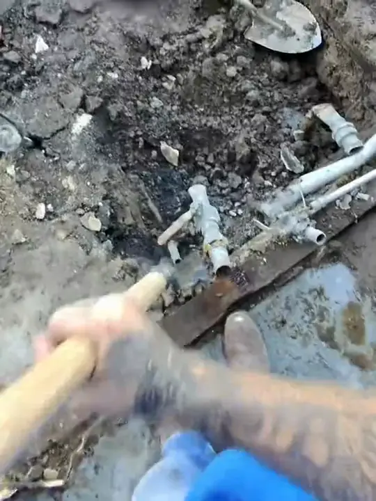 Through Jacob's glasses: a shovel and a demolition hammer beside old supply lines in a dig